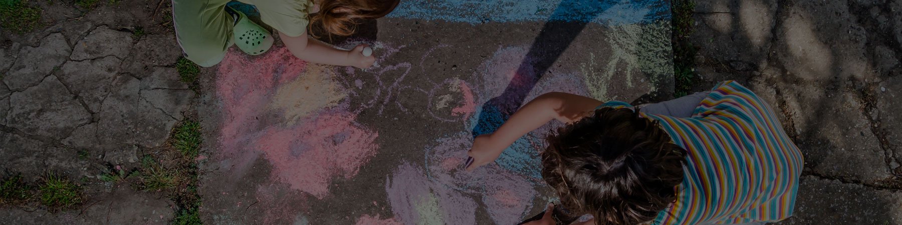 Photo of children doing chalk painting outdoors